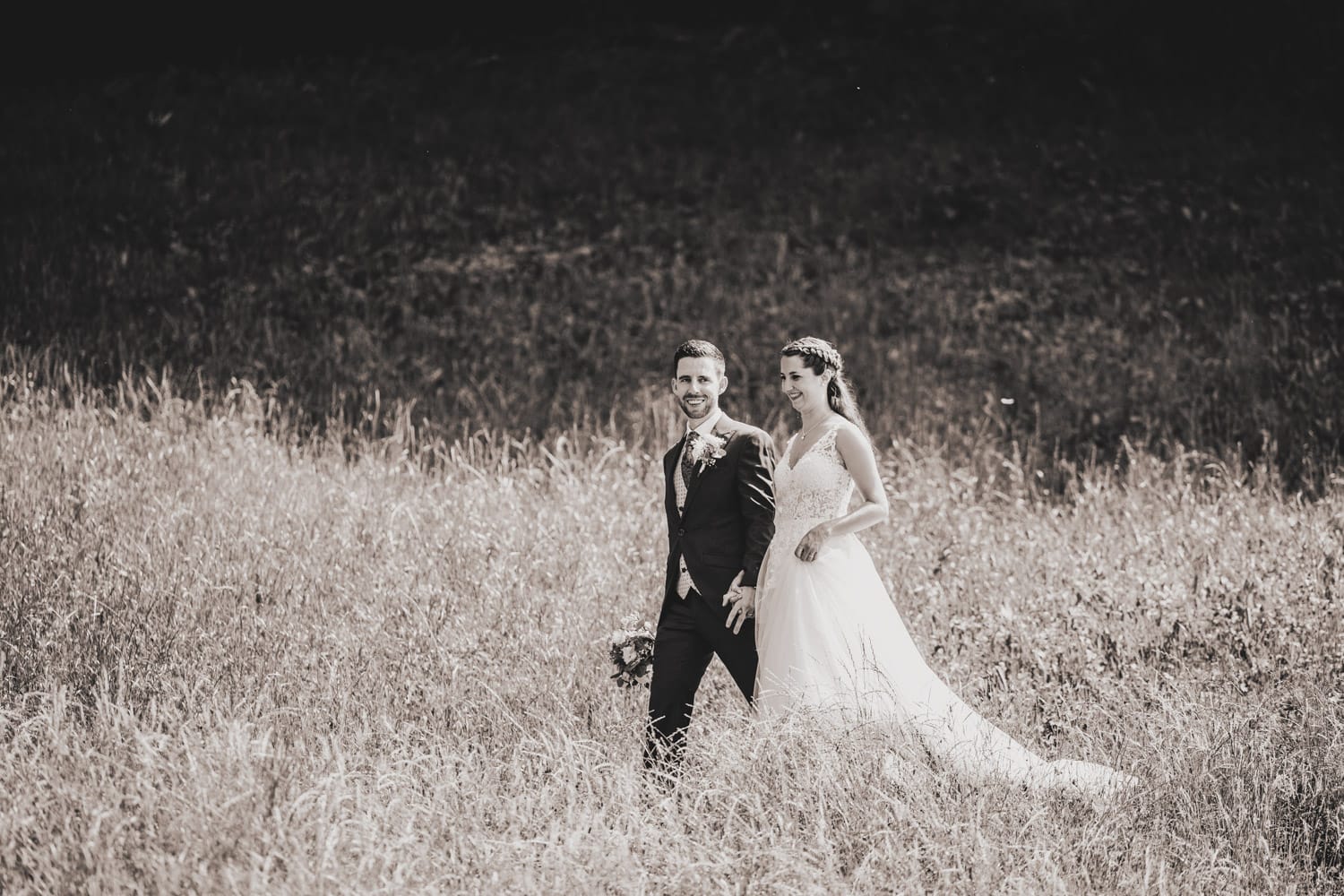 Das Brautpaar spaziert gemeinsam durch eine idyllische Wiese in Vitznau.