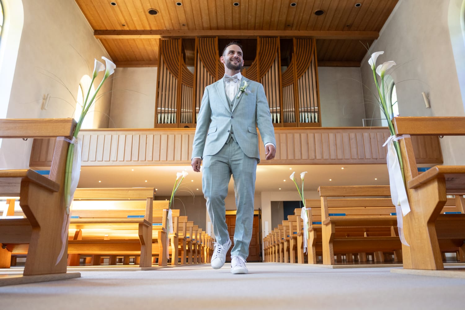 Bräutigam schreitet durch die Kirche in Wangs vor der Trauung.