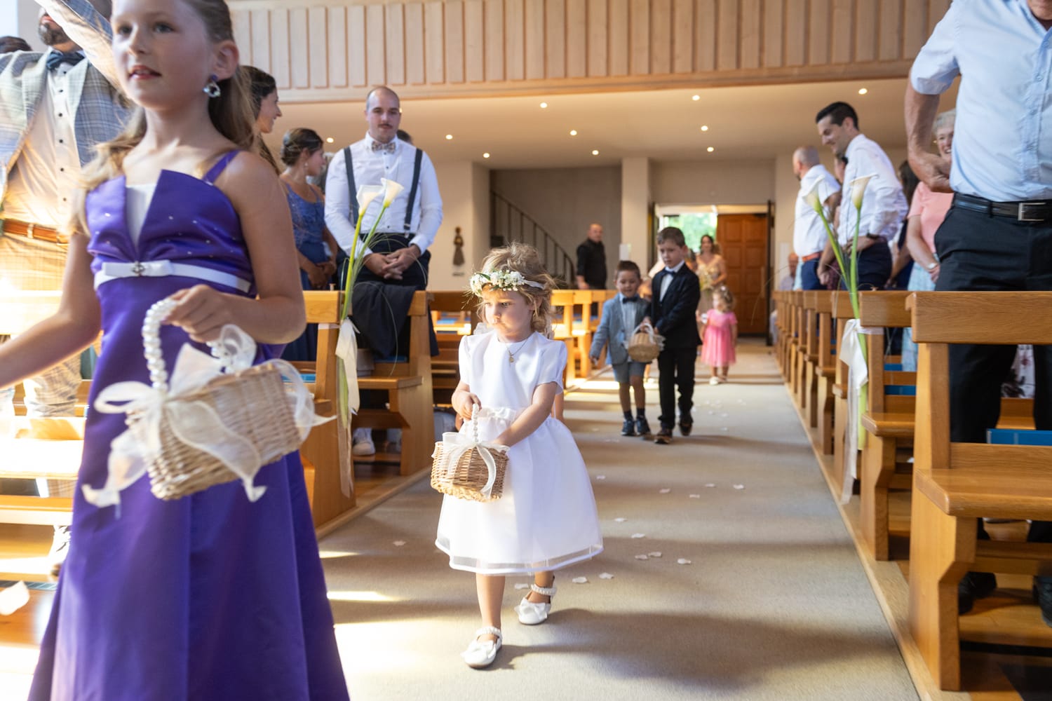 Blumenkinder schreiten durch die Kirche in Wangs während der Trauung.