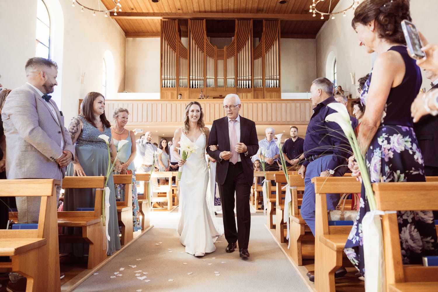 Die Braut schreitet mit ihrem Vater durch die Kirche in Wangs zum Altar.