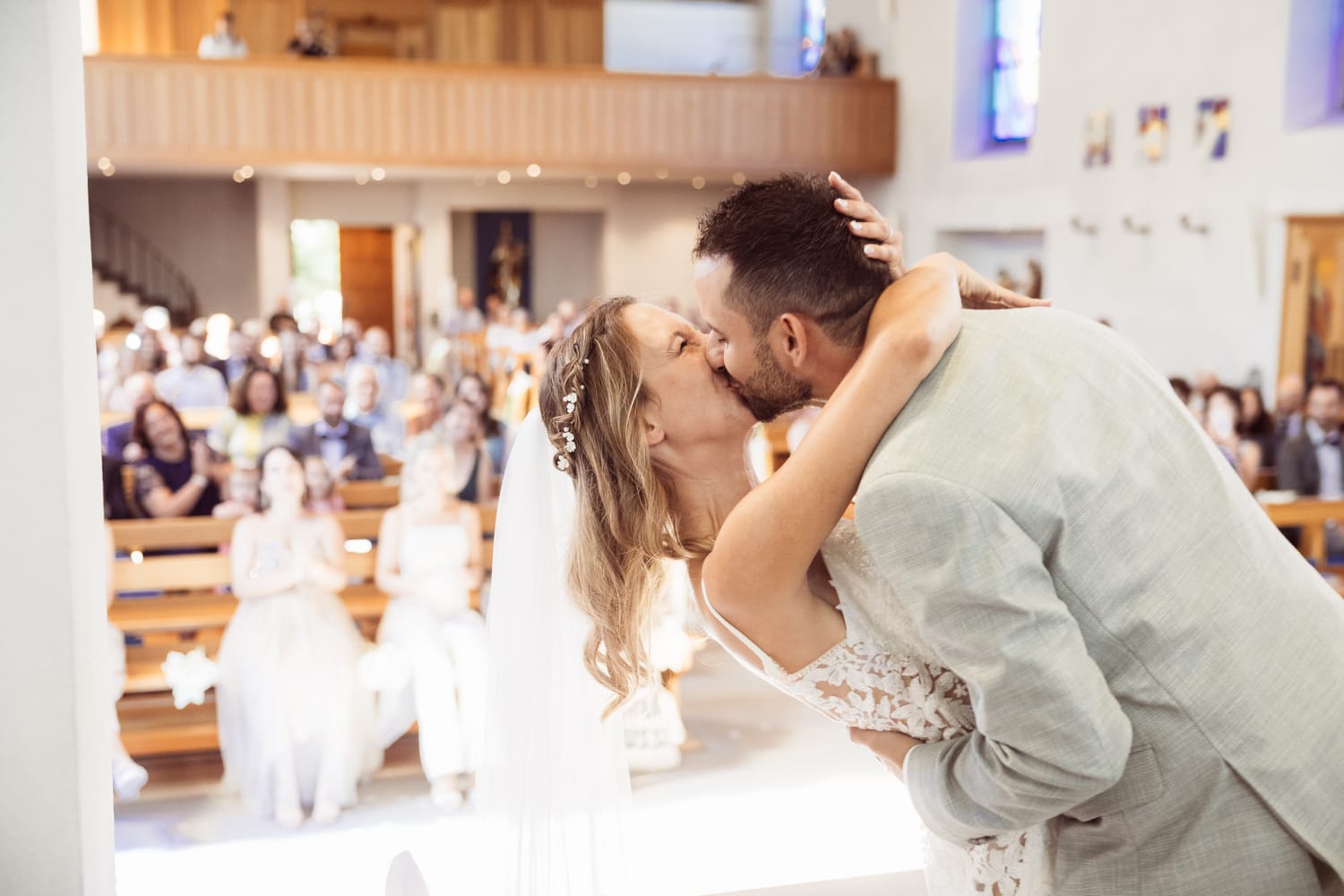 Braut und Bräutigam küssen sich nach der Trauung in Wangs. Titel: Der Hochzeitskuss in der Kirche von Wangs.