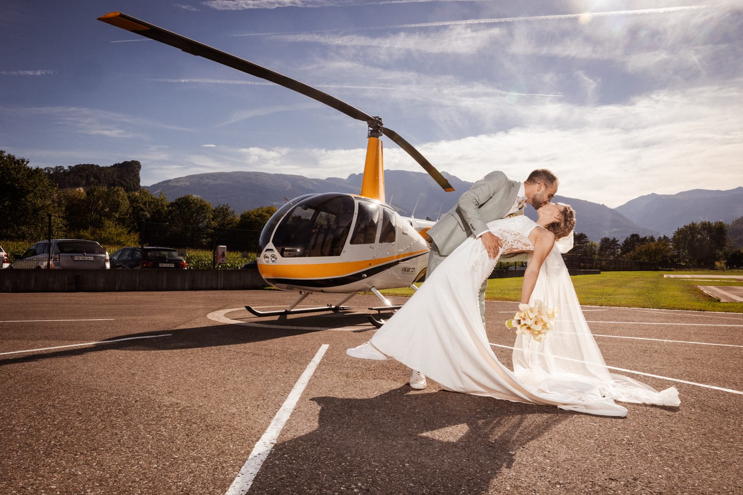 Hochzeitspaar vor Helikopter in Balzers, romantischer Kuss, Hochzeitsfotograf Adrian Flütsch.