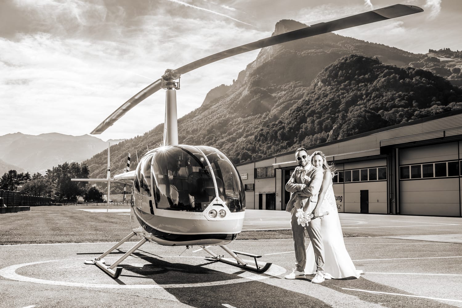 Hochzeitspaar vor Helikopter und Bergen in Balzers, Hochzeitsfotograf Adrian Flütsch.