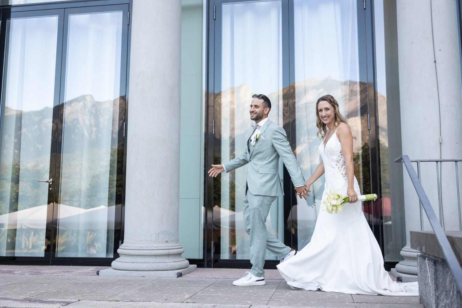 Brautpaar schreitet Hand in Hand zur Hochzeitslocation im Grand Resort Bad Ragaz.