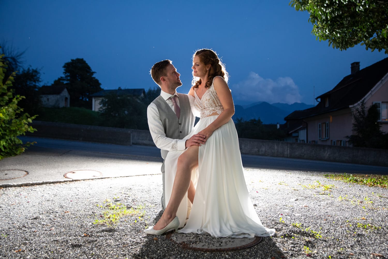 Brautpaar im romantischen Moment während der blauen Stunde in Maienfeld – Hochzeit in Graubünden, festgehalten von Hochzeitsfotograf Adrian Flütsch.
